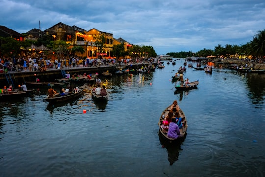 people riding on boat on river during daytime in Hoi An Ancient Town Vietnam
