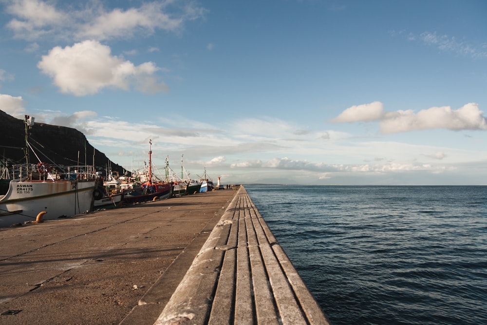 brown wooden dock on sea under blue sky during daytime