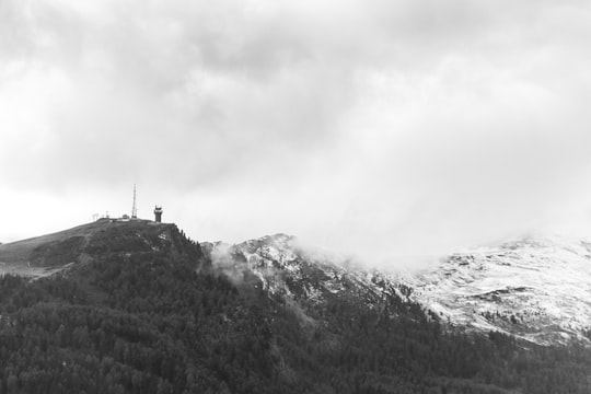 grayscale photo of person standing on top of mountain in Land Salzburg Austria