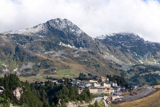 white and brown concrete buildings near mountain under white clouds during daytime in Land Salzburg Austria