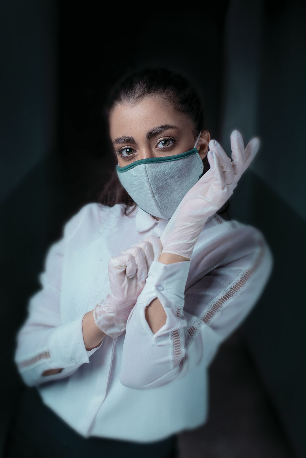 woman in white long sleeve shirt covering face with hand