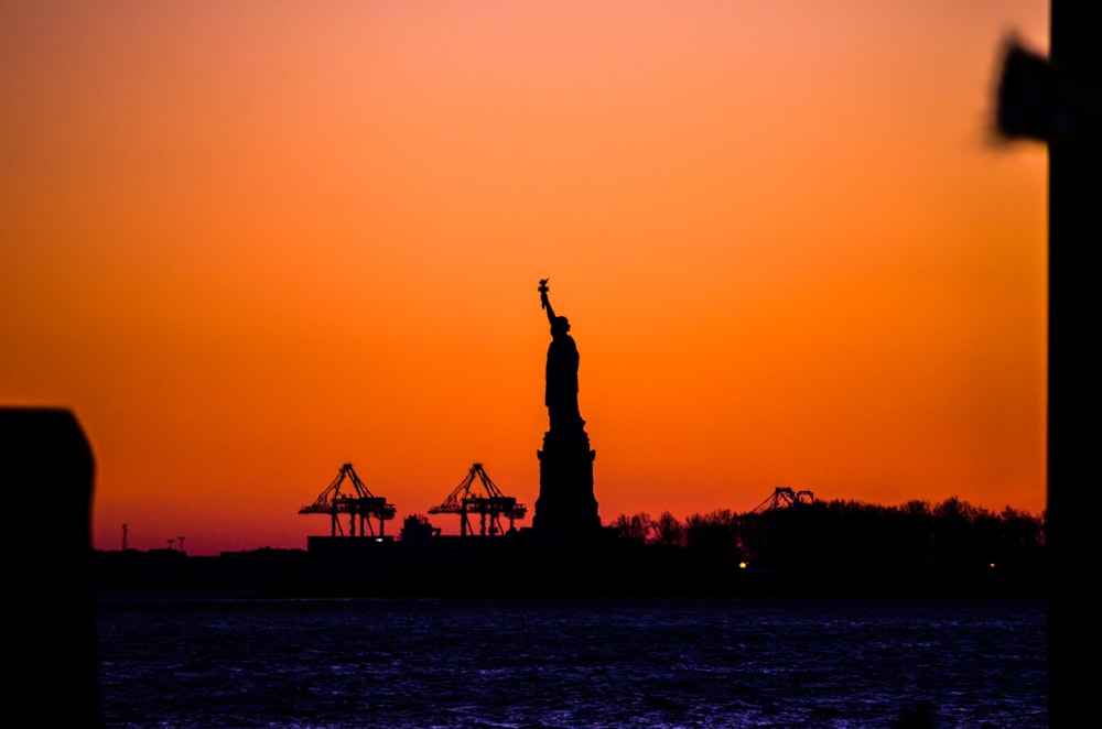 silhouette della statua della libertà durante il tramonto