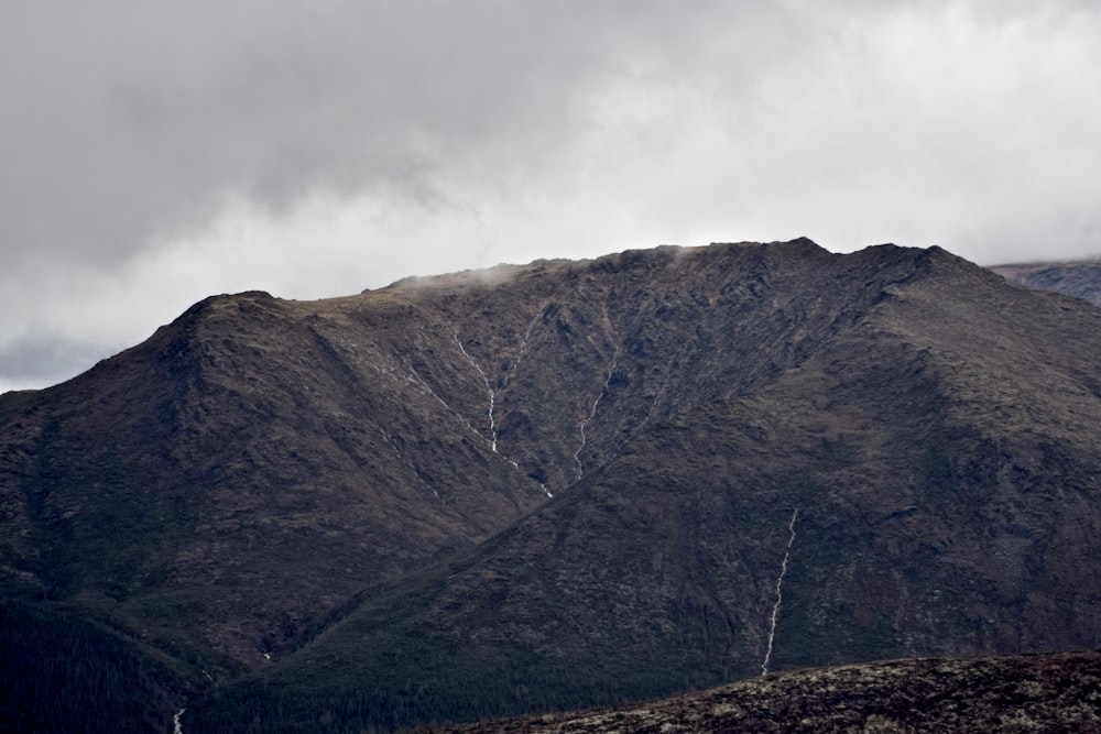 green and brown mountain under white clouds during daytime