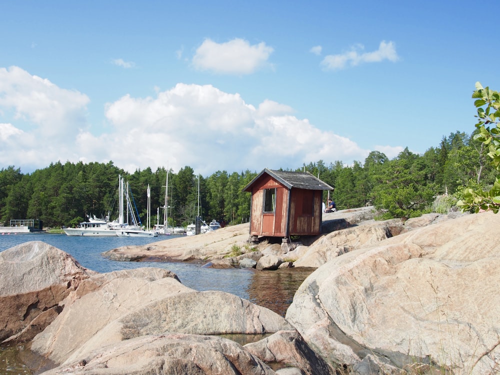 brown wooden house near body of water during daytime