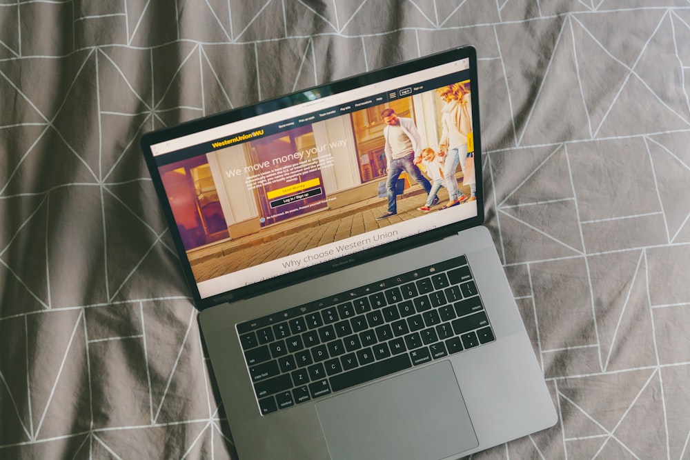 macbook pro on gray textile