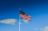 us a flag on pole under blue sky during daytime