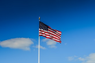 An American flag waving proudly against a clear blue sky.