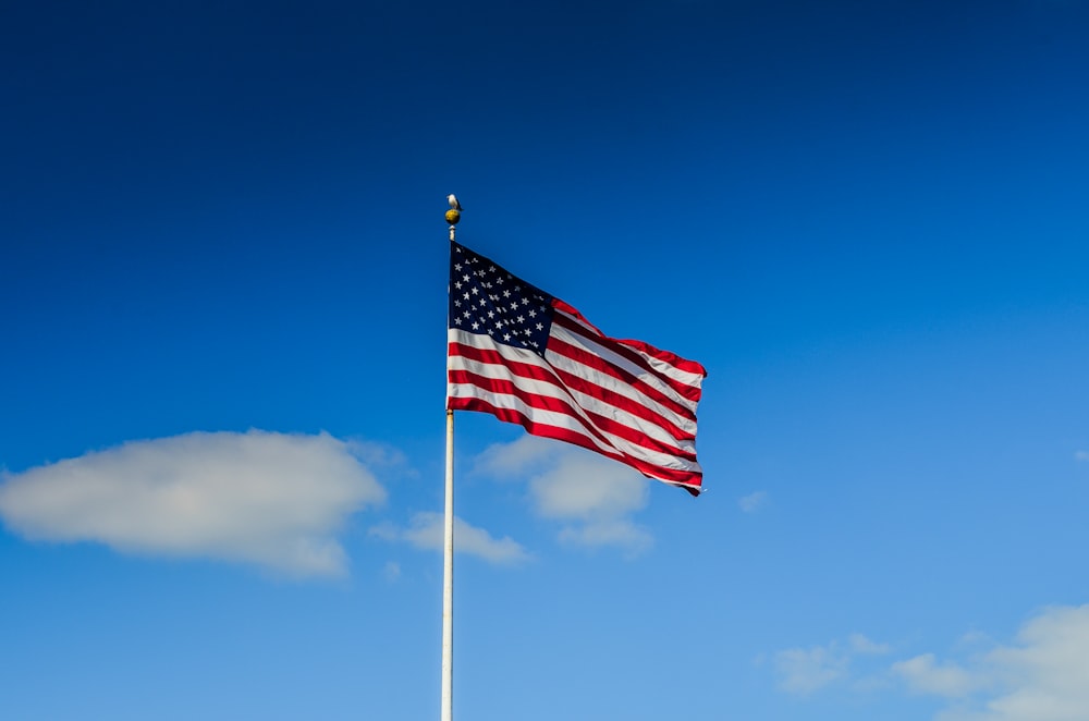 US eine Flagge auf der Stange unter blauem Himmel während des Tages