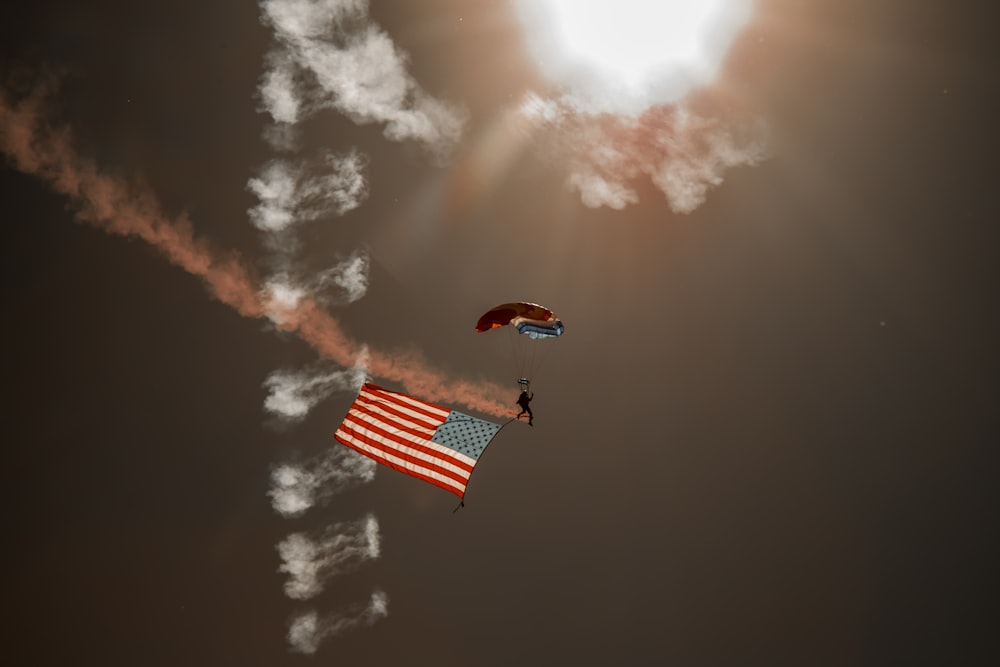 person in red parachute under cloudy sky during daytime