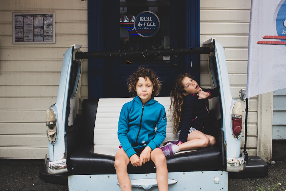 2 women sitting on car