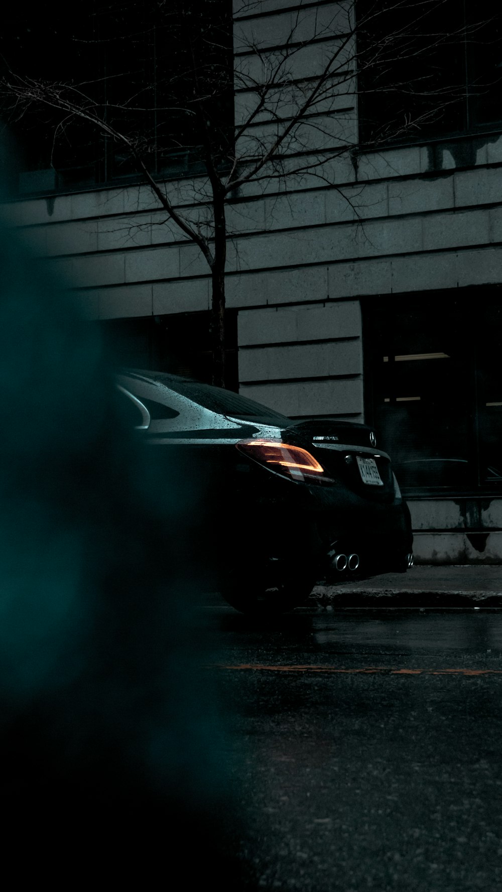 black car parked beside building