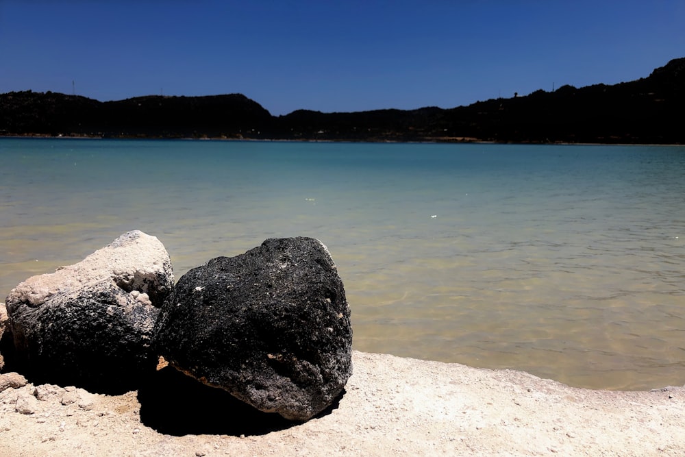 gray rock formation near body of water during daytime