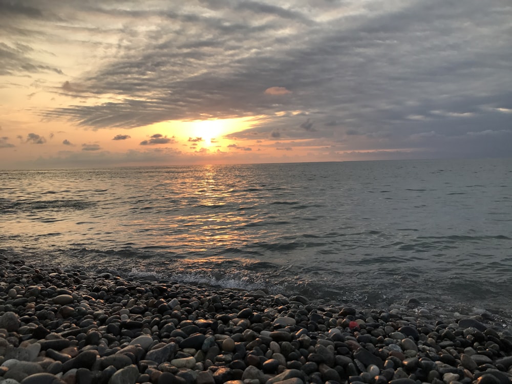 rocky shore during sunset with cloudy sky