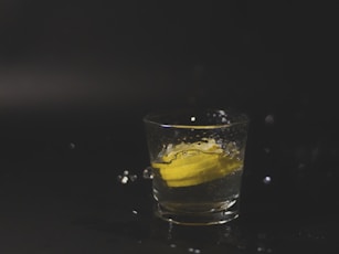 clear shot glass with yellow liquid