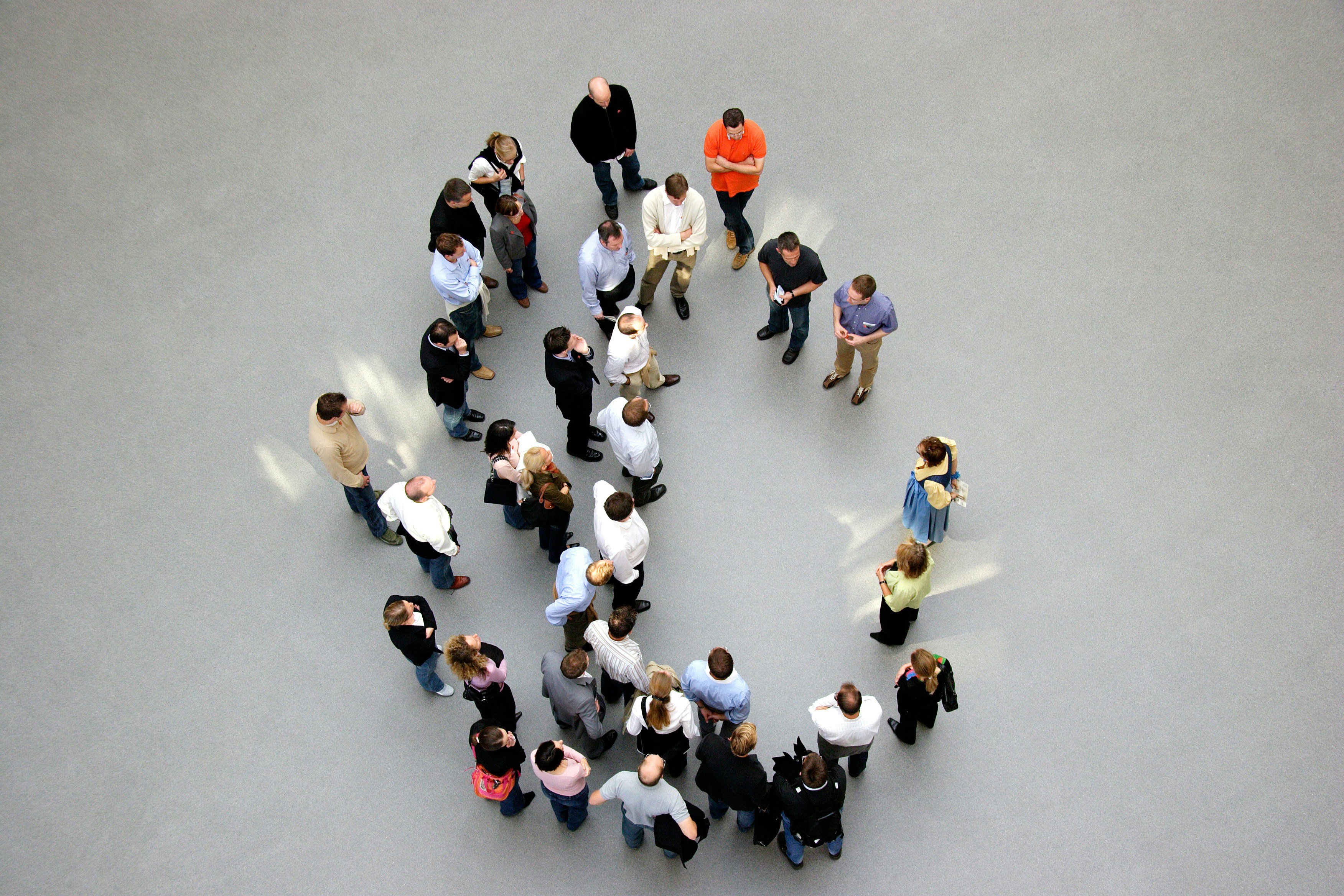 people in white shirts and blue jeans walking on gray concrete floor
