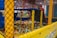 A children's indoor play area is filled with an array of colorful plastic balls enclosed in a mesh fence. The structure includes climbing features and slides, with various vibrant colors used throughout the setup.