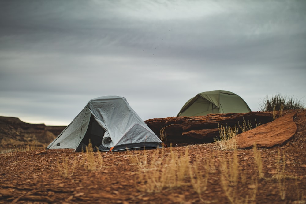 gray tent on brown grass field under gray sky