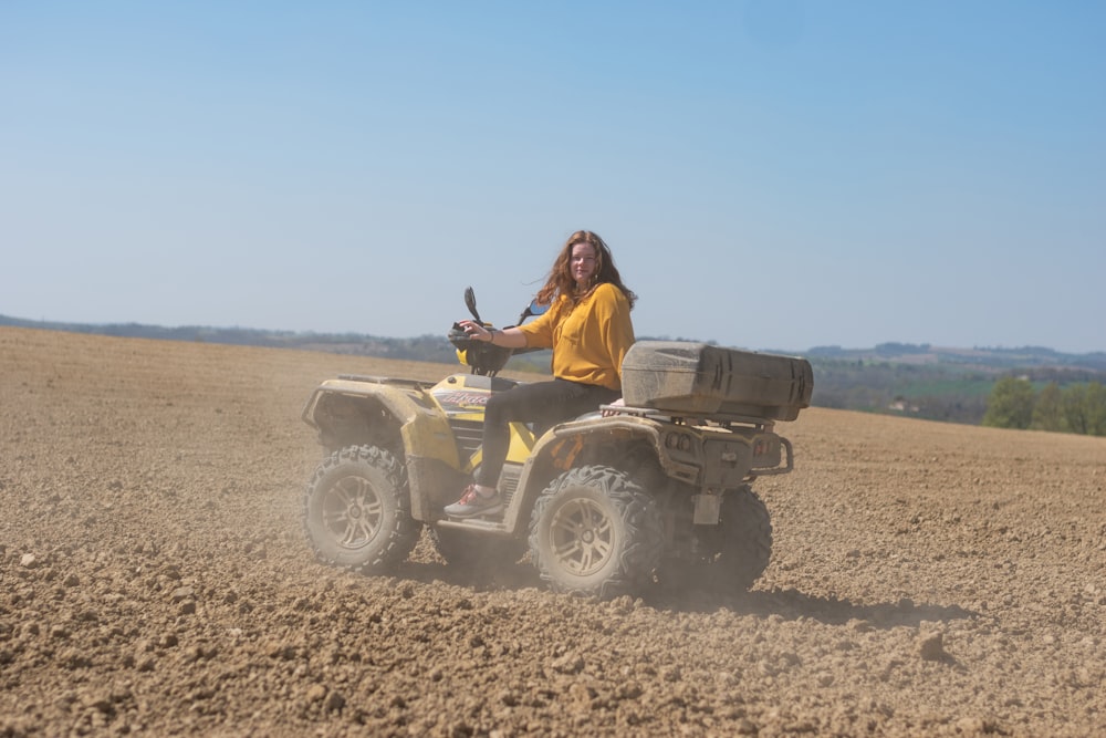 woman in brown jacket riding atv on brown field during daytime