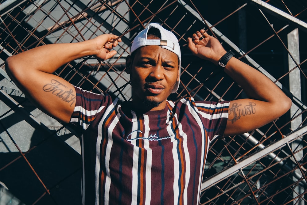 man in white and blue stripe polo shirt wearing white cap