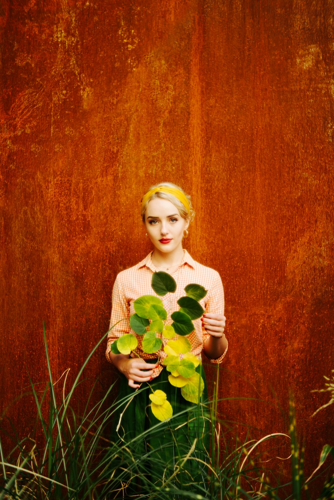 woman in white long sleeve shirt holding yellow flower