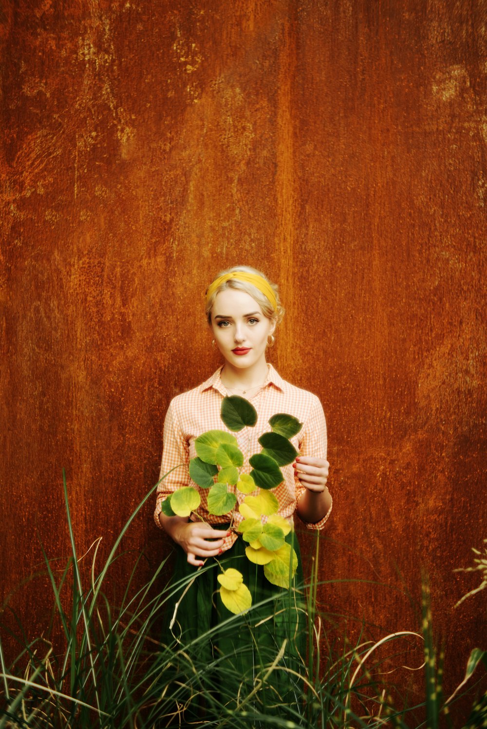 woman in white long sleeve shirt holding yellow flower