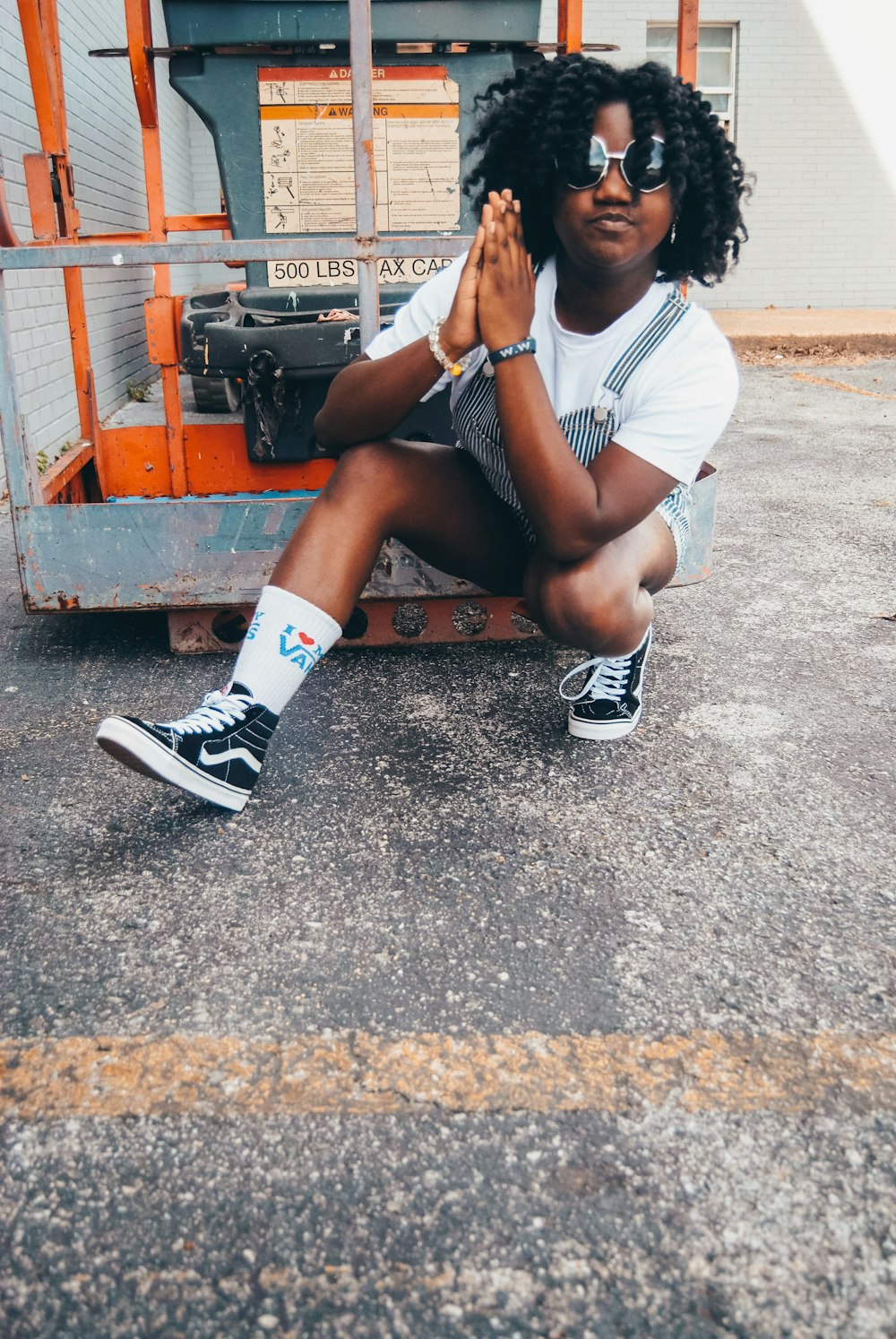 woman in white t-shirt sitting on orange plastic crate