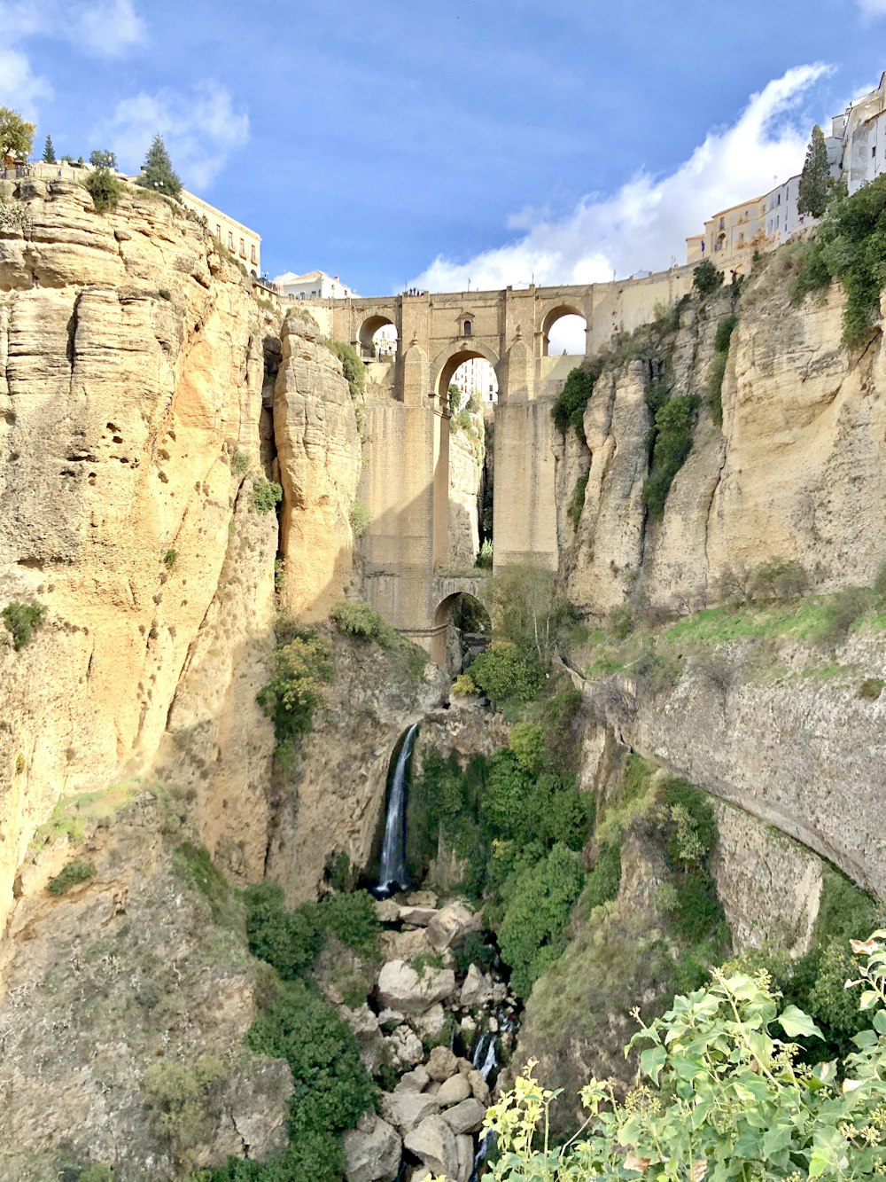 Homme en veste noire debout sur la falaise pendant la journée