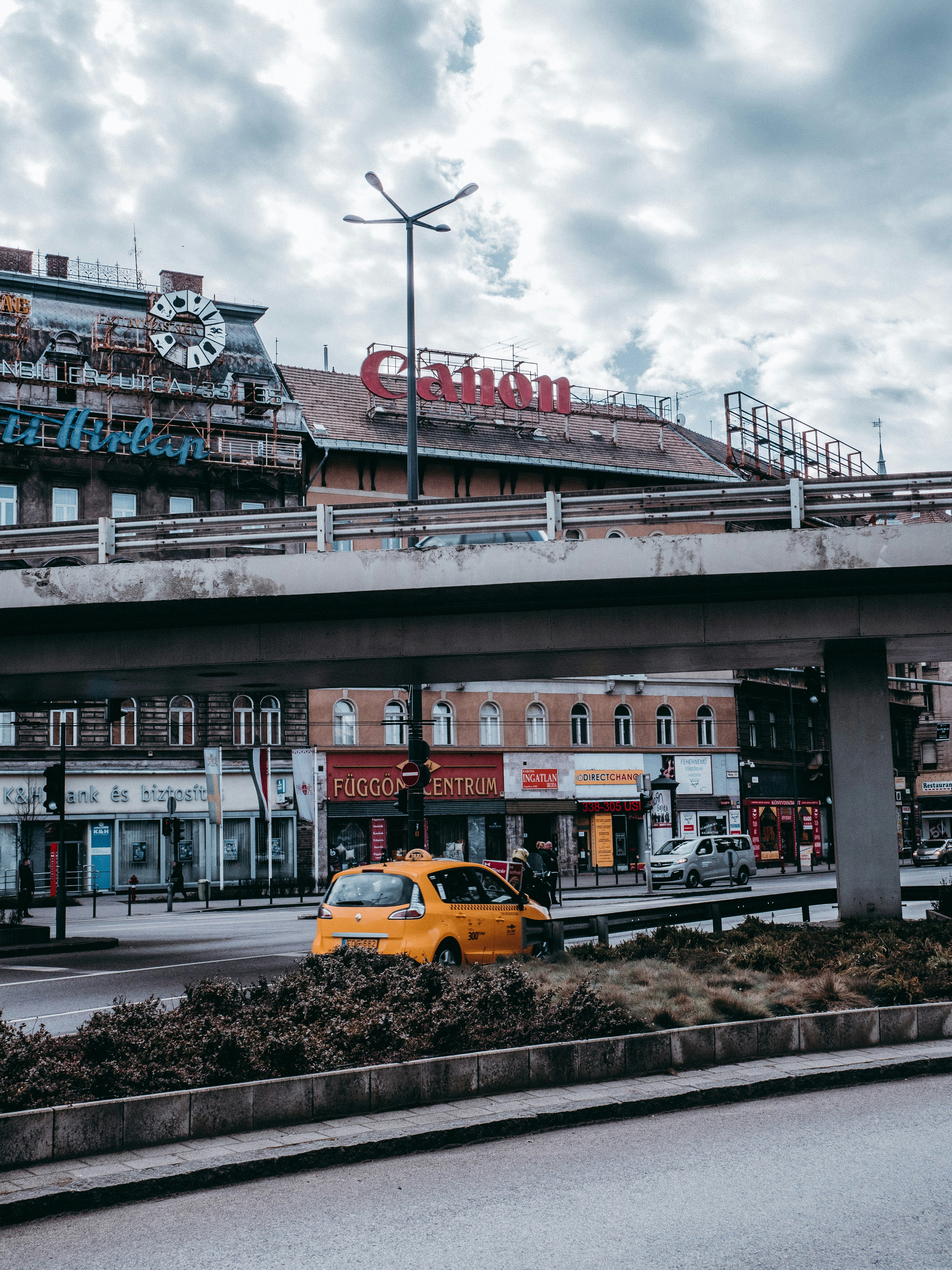yellow taxi cab on road near building during daytime