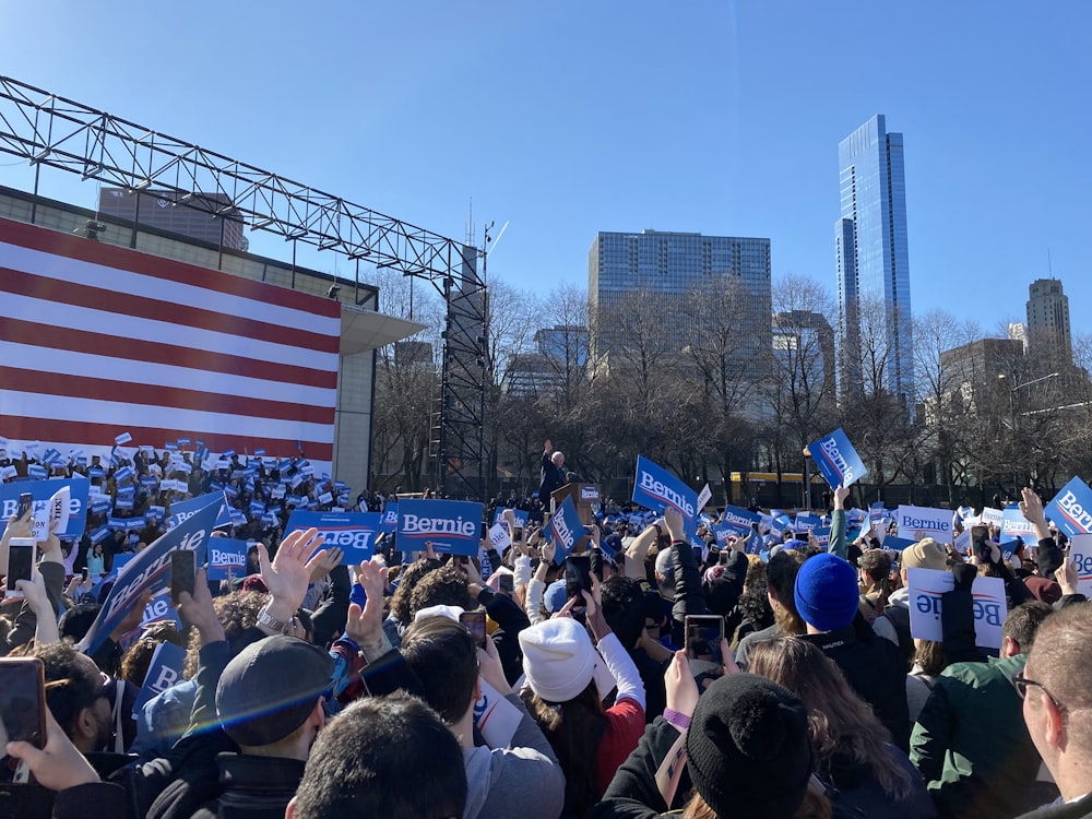 people gathering near us flag during daytime