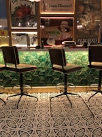 black metal framed green padded chairs