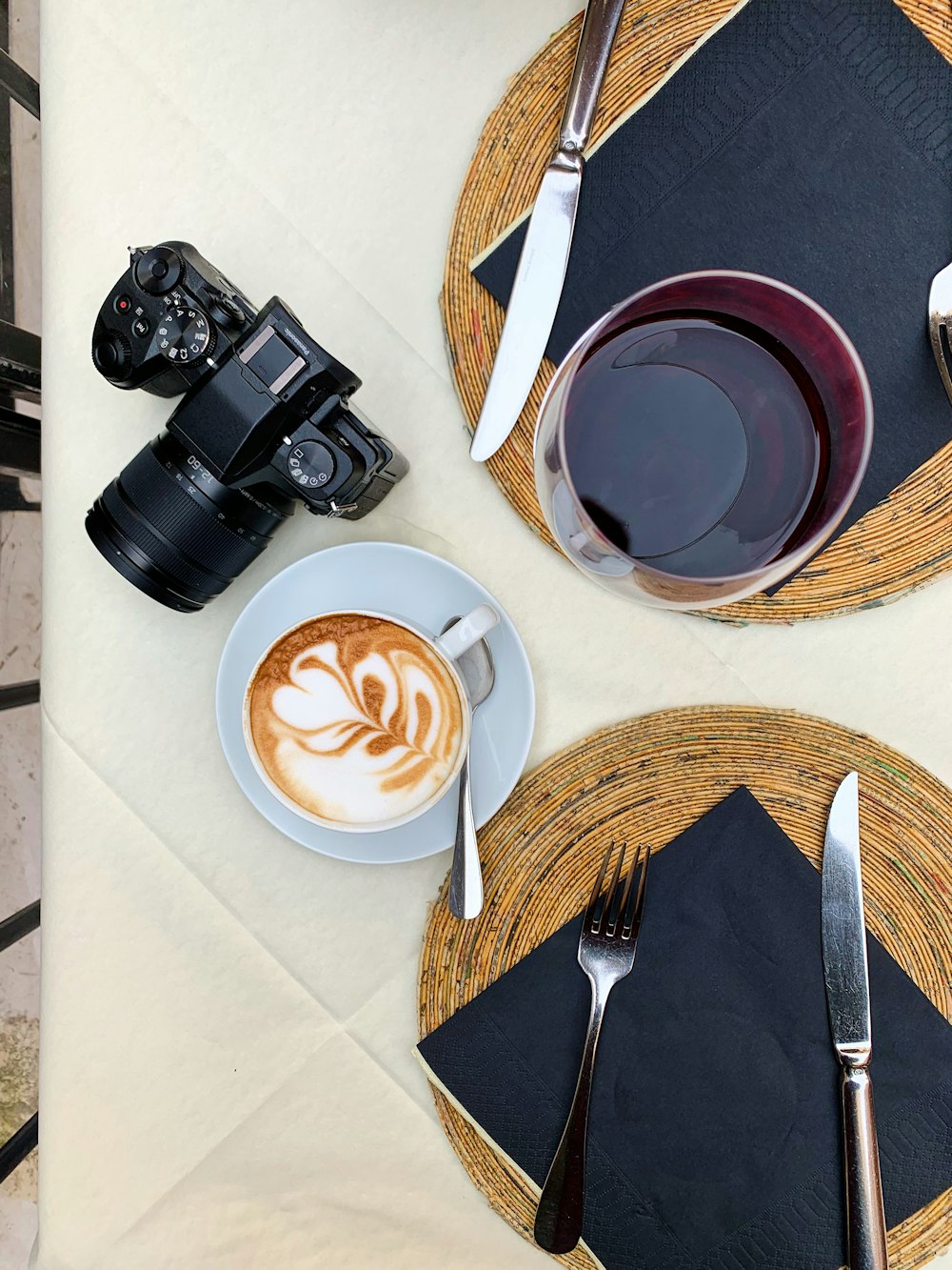 black dslr camera beside white ceramic cup with brown liquid