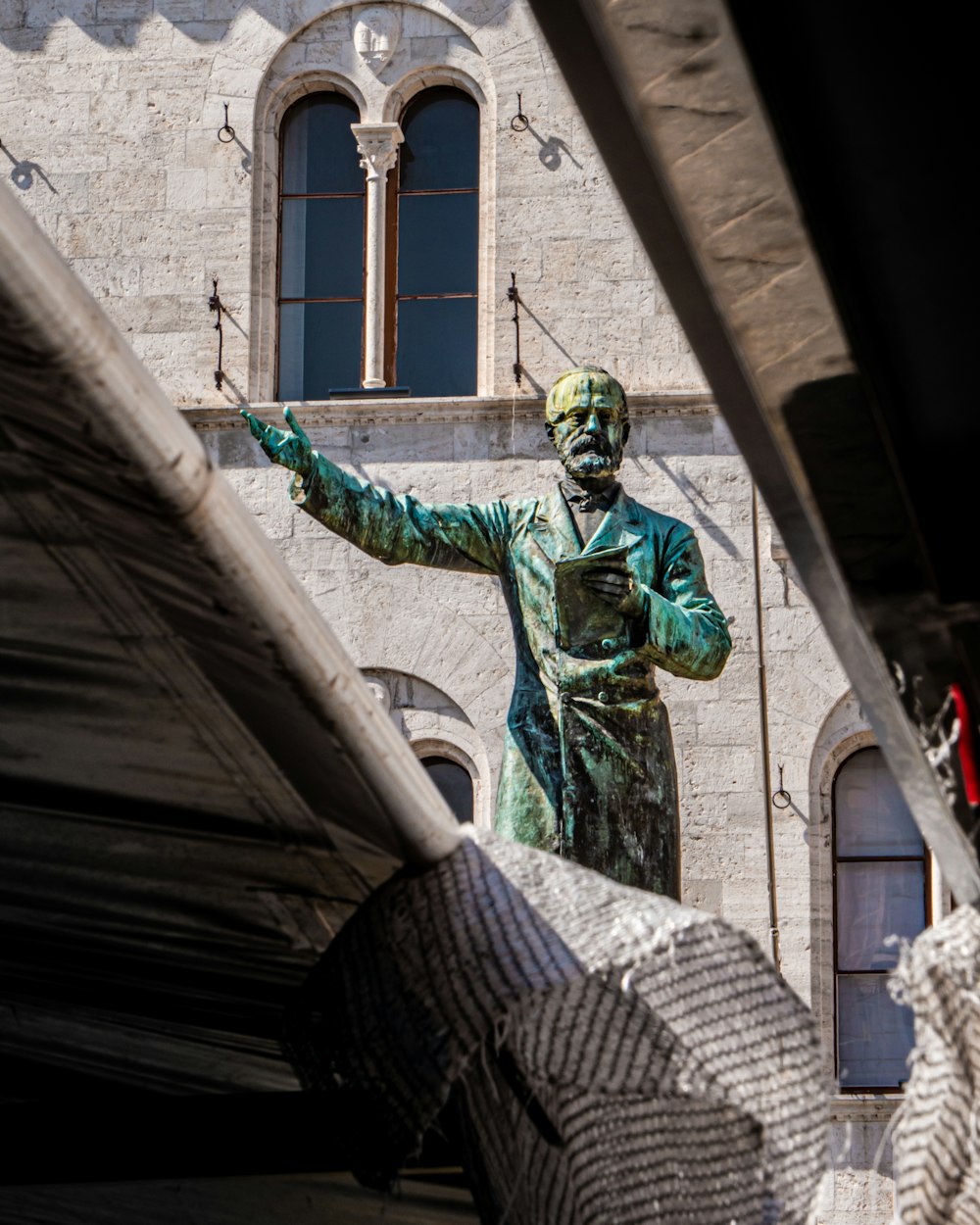 person in green and yellow mask and green mask standing near brown concrete building during daytime