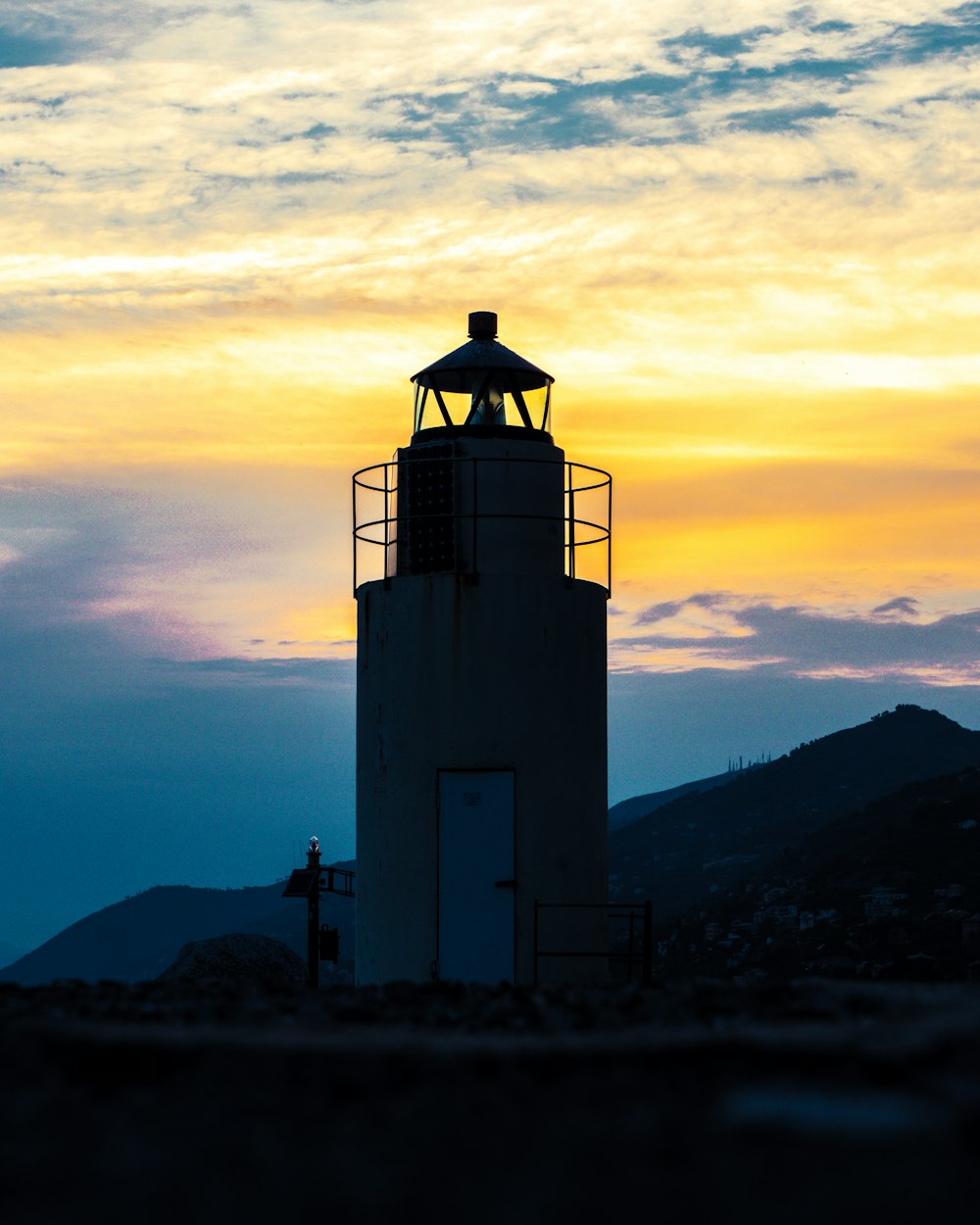 white and black lighthouse during sunset