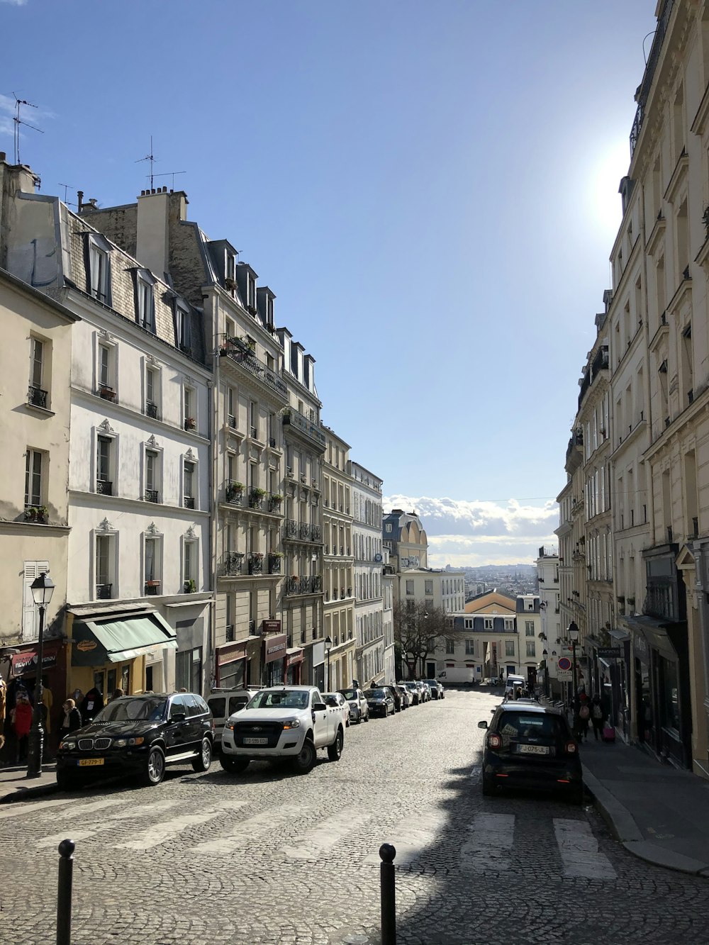 cars parked on side of road near buildings during daytime