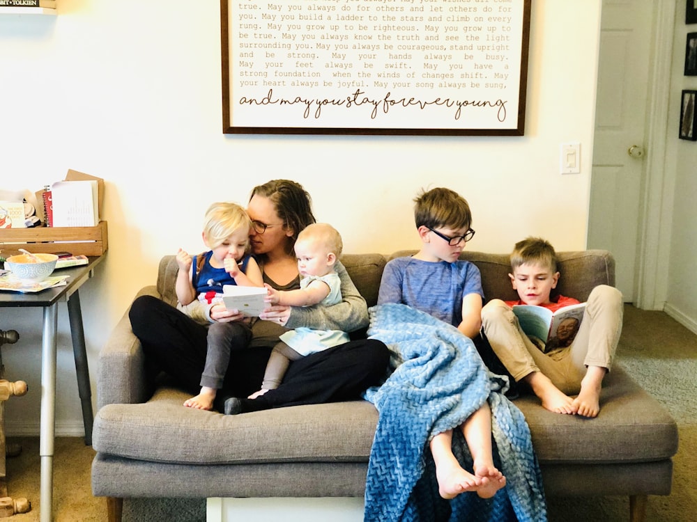 3 children sitting on gray couch