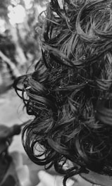 Close-up of creamy conditioner being applied to shiny, healthy hair strands