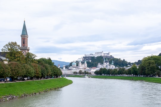 body of water near green grass field under white sky during daytime in Hohensalzburg Castle Austria