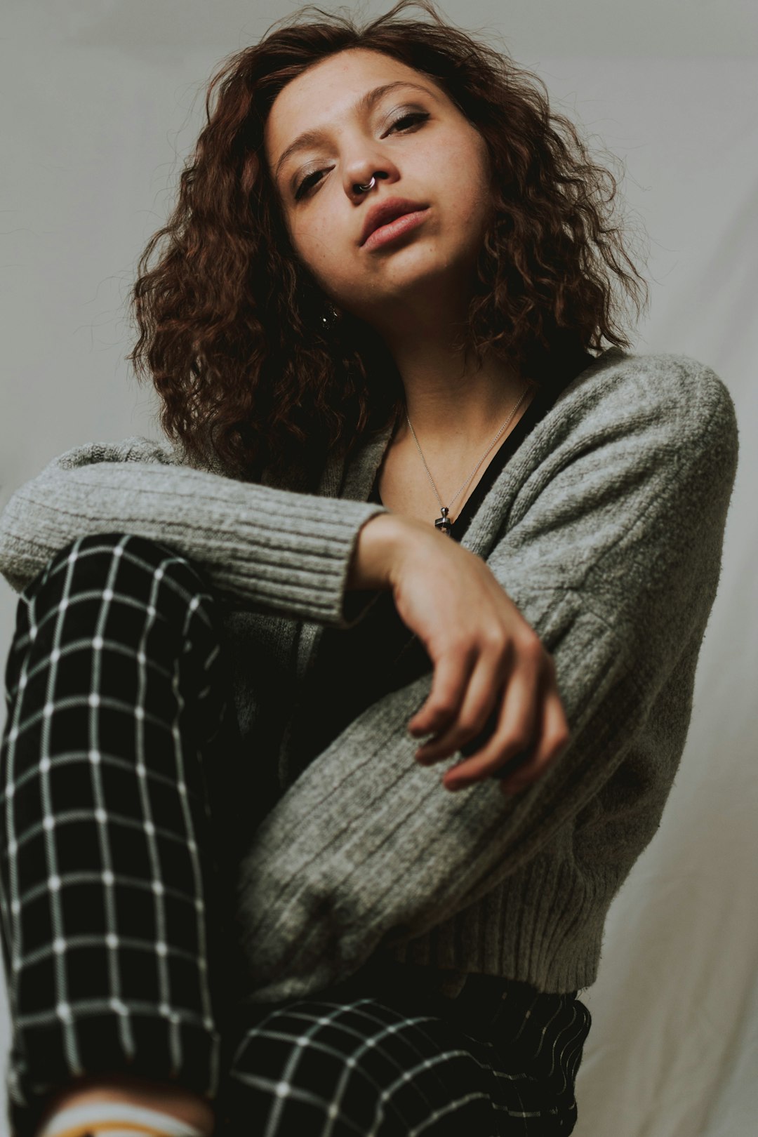 woman in gray cardigan and black and white plaid dress shirt