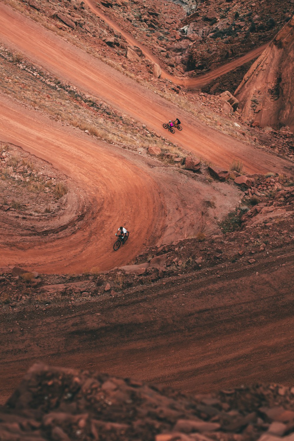 person in black jacket walking on brown sand