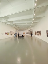 people walking on hallway with white wall