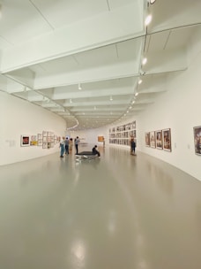 people walking on hallway with white wall