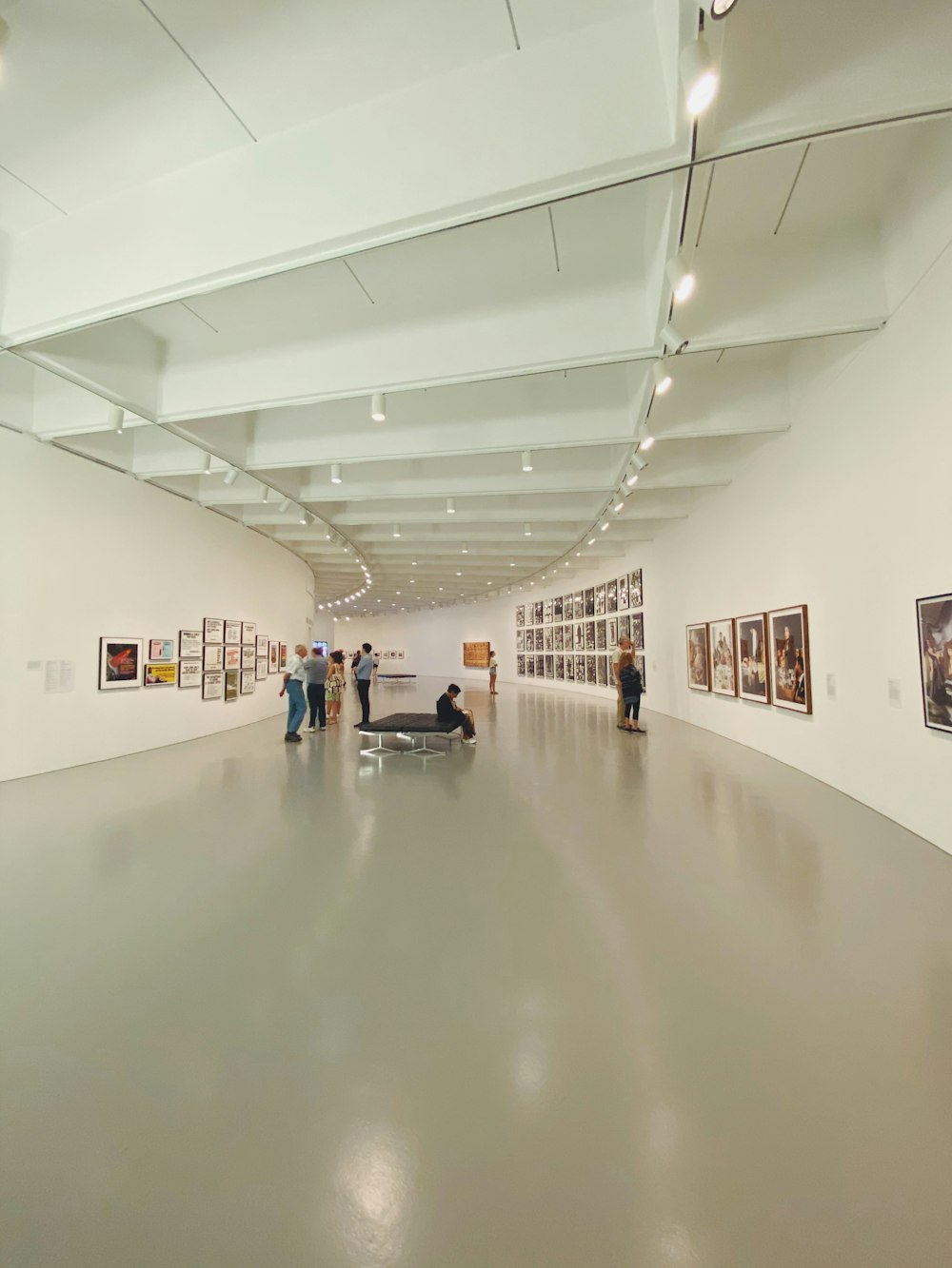 people walking on hallway with white wall