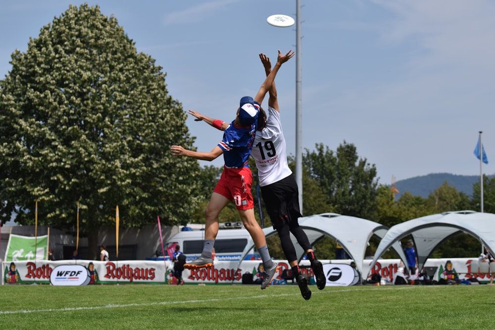 man in blue and white jersey shirt and black shorts playing soccer during daytime