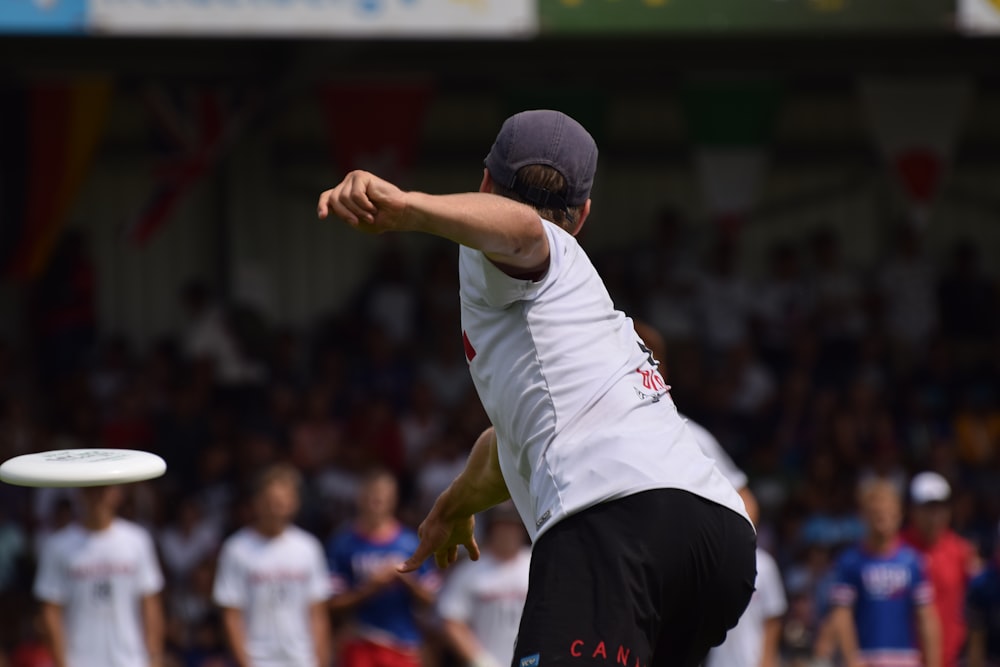 man in white shirt and black shorts running on field