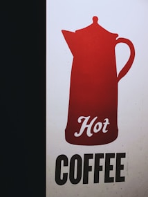 A graphic design featuring a red silhouette of a coffee pot with the word 'Hot' written in cursive script. Beneath the pot, the word 'COFFEE' is presented in bold, black uppercase letters on a light background. The design is simple and eye-catching with a strong contrast between the colors.