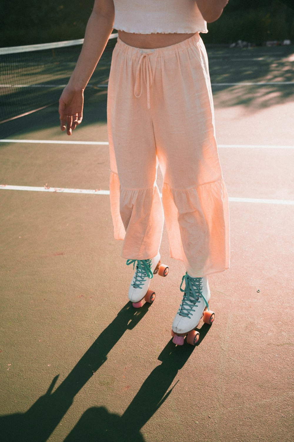 person in pink pants and white sneakers standing on track field