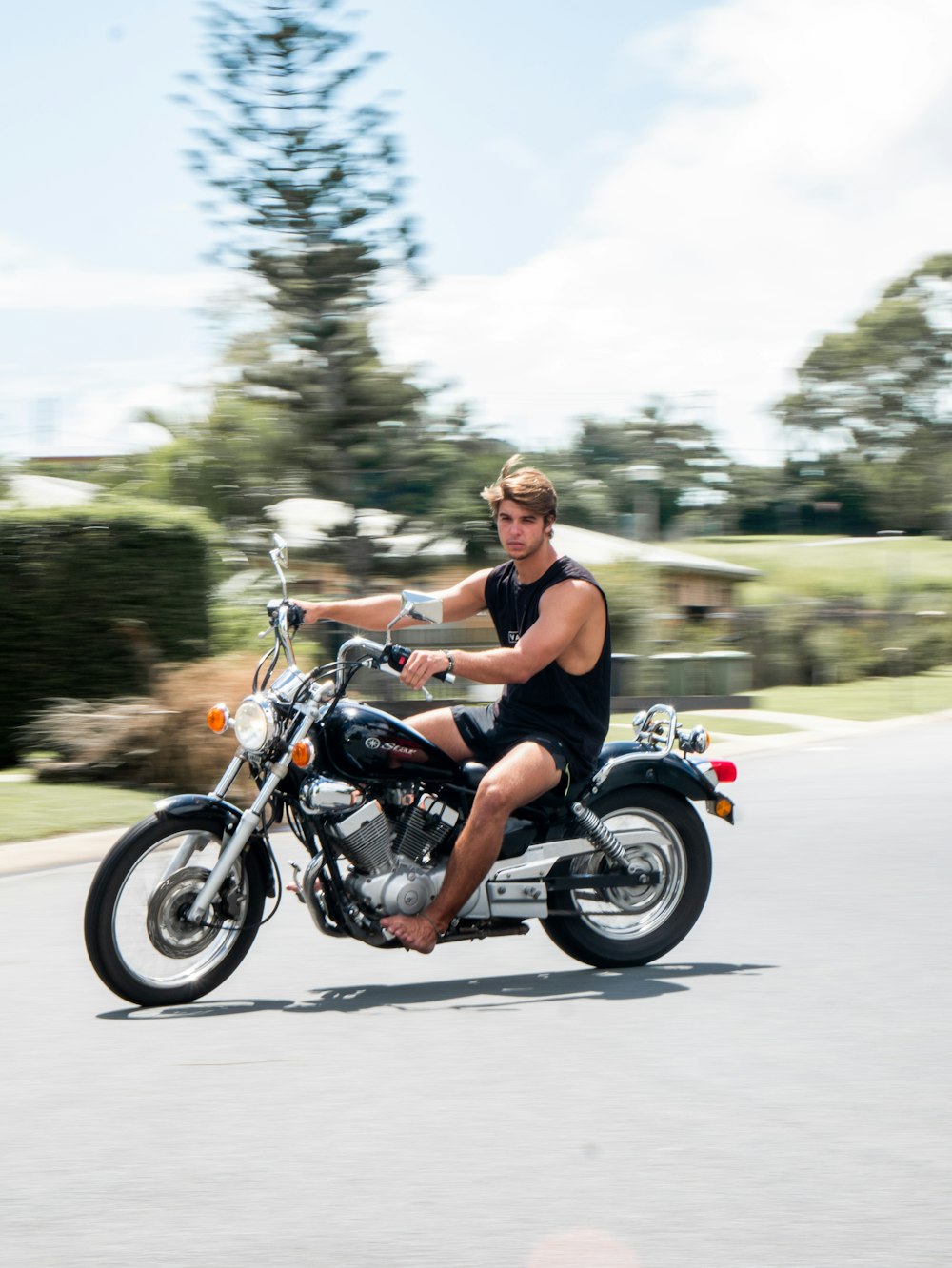 woman in black tank top riding on motorcycle during daytime