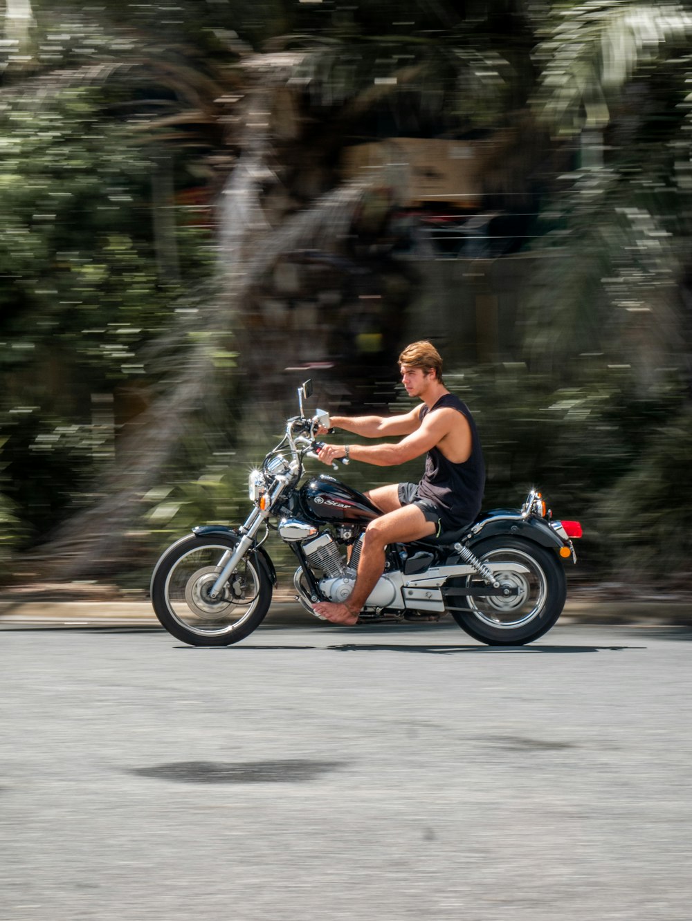 Mann in schwarzen Shorts fährt tagsüber Motorrad auf der Straße