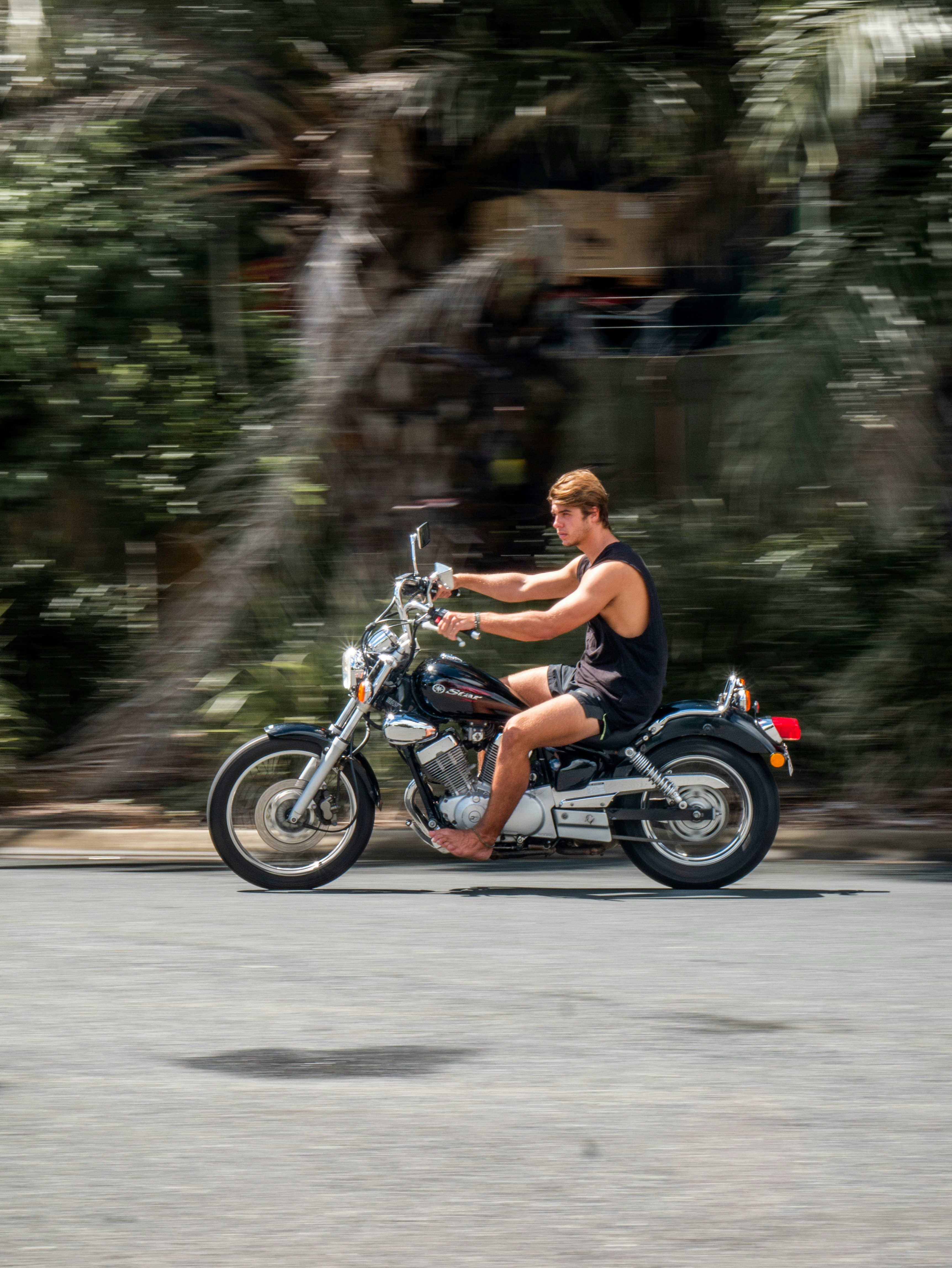 man in black shorts riding motorcycle on road during daytime