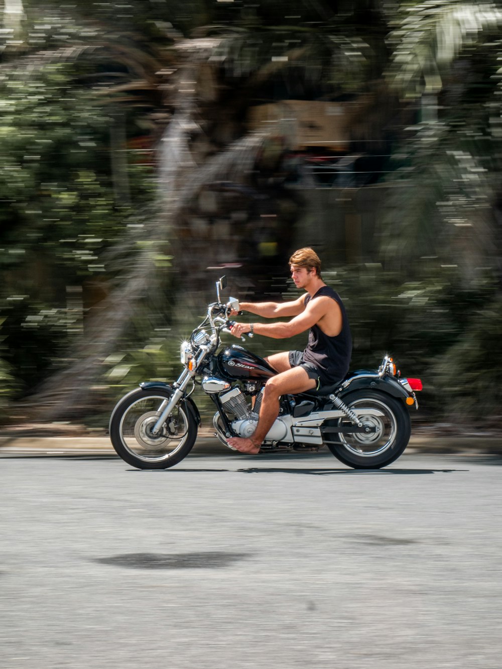 man in black shorts riding motorcycle on road during daytime